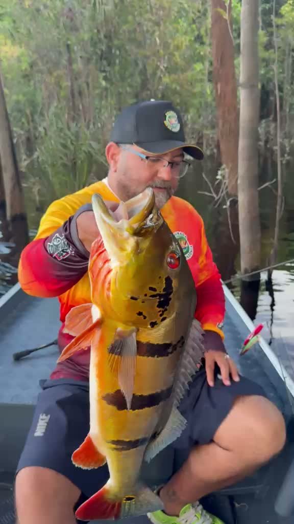 Pescador mostrando um tucunaré durante a pescaria